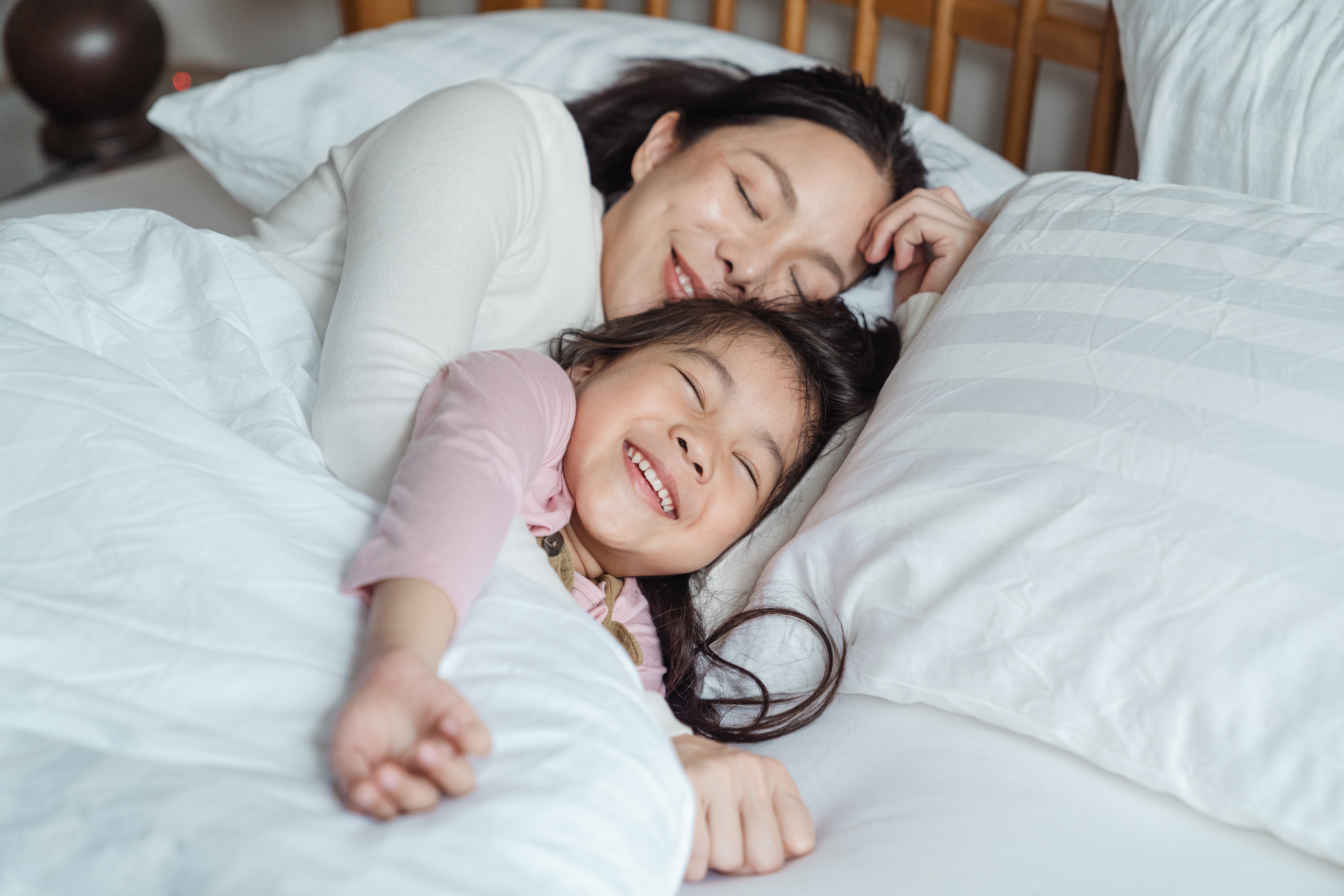 Mother and daughter sleeping comfortably in a cool home